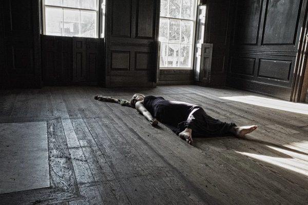 žena leží na podlahe domu